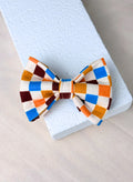 A multi coloured checkered dog bow tie